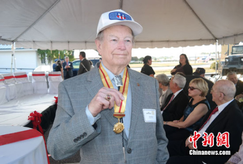 当地时间9月19日,美国陈纳德航空军事博物馆以“飞虎将军”陈纳德回忆录《战士之路》命名的展馆开幕,记述了陈纳德第二次世界大战期间与中国人民并肩战斗和生活的精彩经历。纪念仪式上,中国驻休斯敦总领馆和山东玉皇化工有限公司向5位“飞虎队”老兵颁发刻有“中美人民友谊万岁”字样的纯金纪念牌,感谢他们在世界反法西斯战争中的贡献。图为原美国空军运输大队驼峰航线飞行员杰·温雅德现场展示习近平主席在北京为他颁发的“中国人民抗日战争胜利70周年”纪念章。 王欢 摄 当地时间9月19日,美国陈纳德航空军事博物馆以“飞虎将军”陈纳德回忆录《战士之路》命名的展馆开幕,记述了陈纳德第二次世界大战期间与中国人民并肩战斗和生活的精彩经历。纪念仪式上,中国驻休斯敦总领馆和山东玉皇化工有限公司向5位“飞虎队”老兵颁发刻有“中美人民友谊万岁”字样的纯金纪念牌,感谢他们在世界反法西斯战争中的贡献。图为原美国空军运输大队驼峰航线飞行员杰·温雅德现场展示习近平主席在北京为他颁发的“中国人民抗日战争胜利70周年”纪念章。 王欢 摄